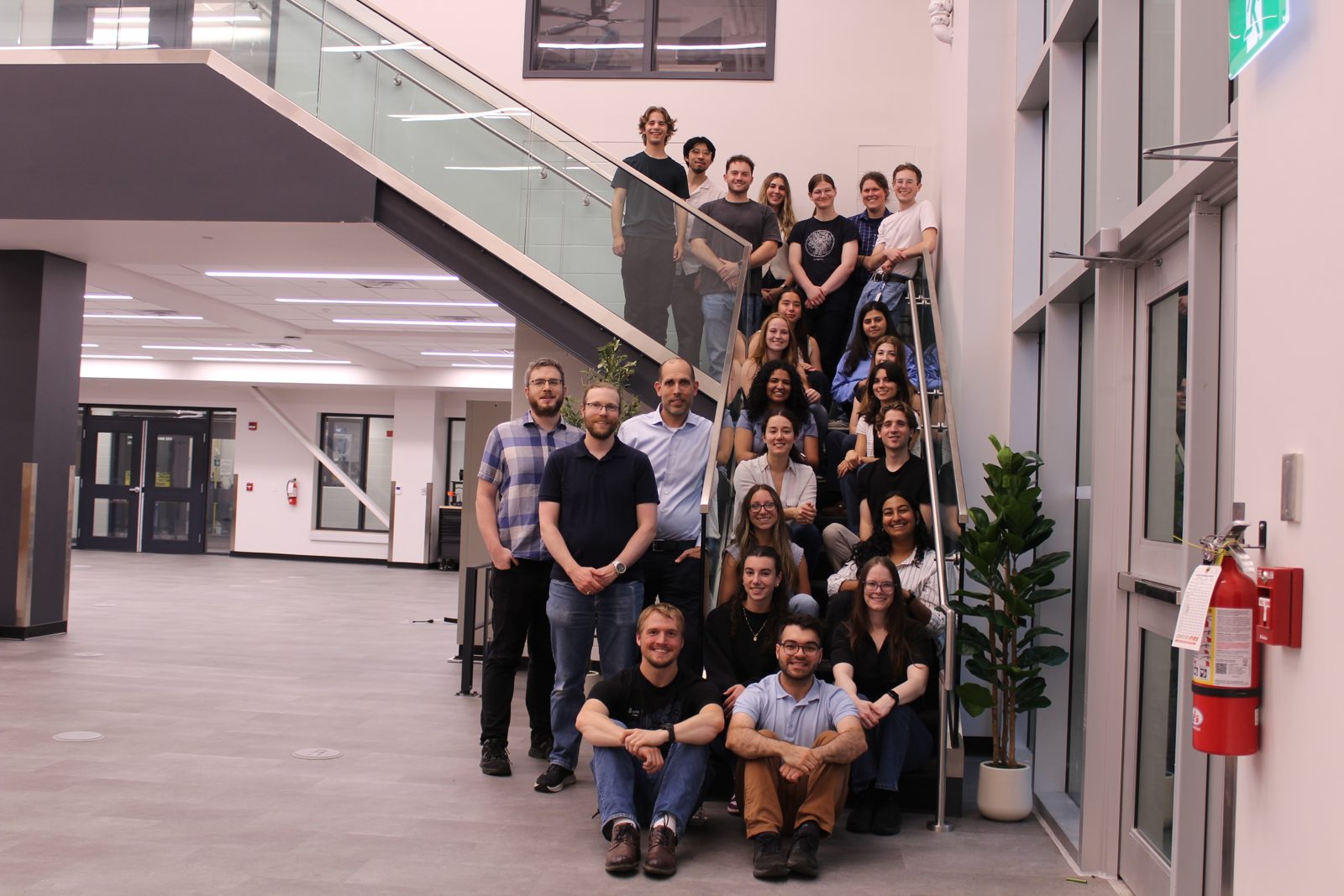 The research team posed on a glass staircase, with Joel seated in the front row